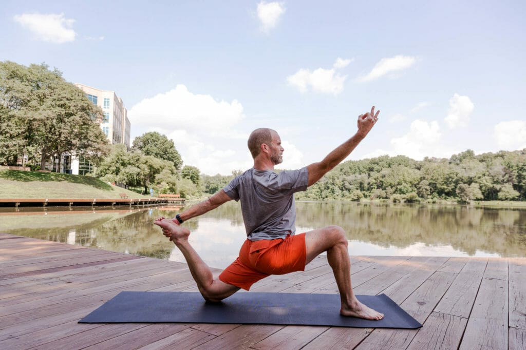 A man practices yoga lakeside in Columbia, Maryland.
